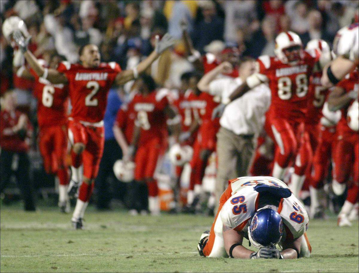 Former Boise State offensive lineman Klayton Adams falls to the turf as Louisville celebrates their 44-40 win over the Broncos on New Year’s Eve in the 2004 Liberty Bowl in Memphis.