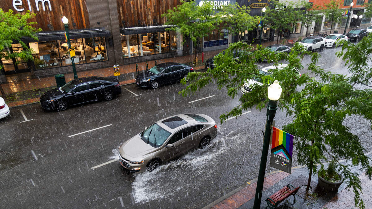 A vehicle splashes through a flooded area of downtown Boise during a flash thunderstorm that dropped up to 1.5 inches of rain in less than 90 minutes in parts of downtown Tuesday night. Hail was also reported.