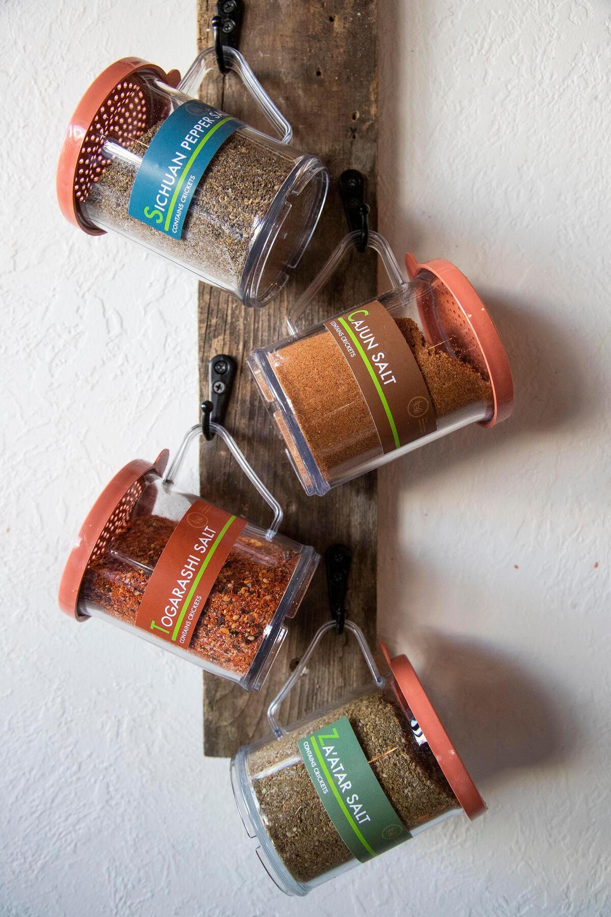 A wall rack at Boise Fry Co. holds the four shaker bottles with cricket spice mixtures. A sign above the rack and labels on the bottles explains what’s in the mixtures so there are no surprises.