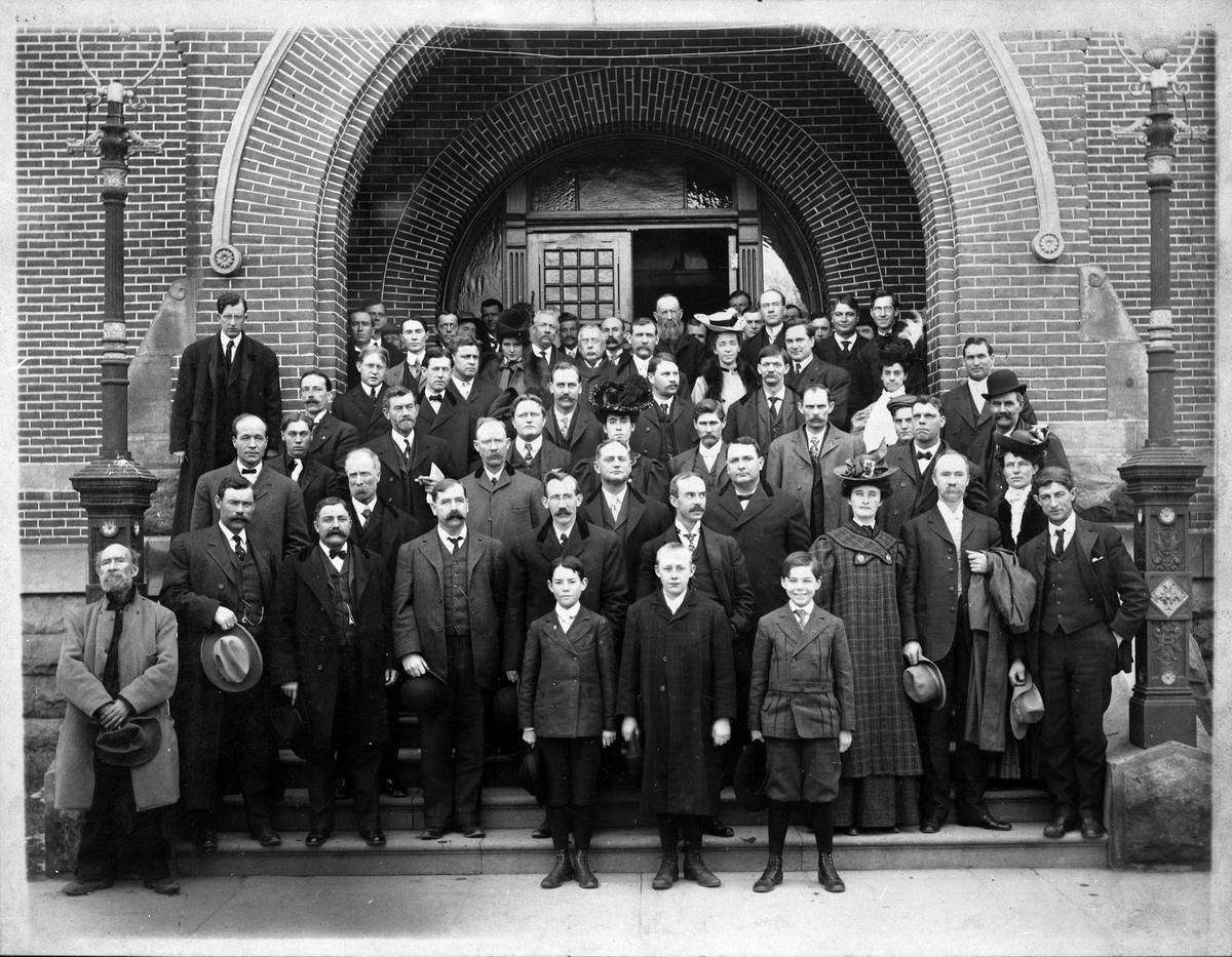The Idaho State Legislature posed for their annual photo on the steps of the Old Capitol Building (date unknown). Guess who also showed up? James Hogan is far left, front row. 