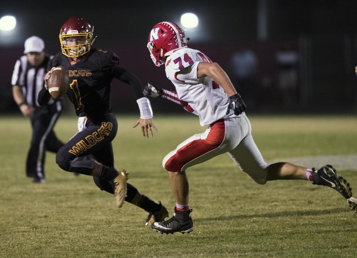 Columbia quarterback Austin Collett looks for options while on the run from Nampa defensive end Alex Ashley on Sept. 28 at Columbia High.