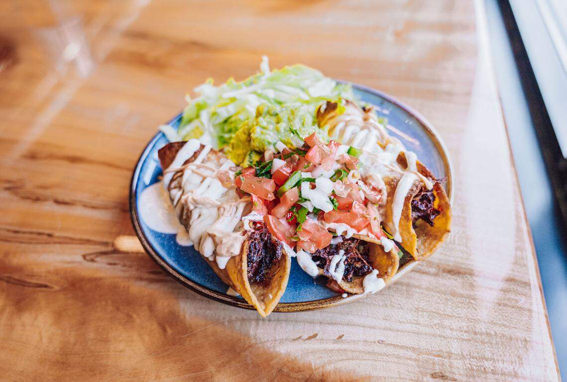 Taquitos ($10): Three taquitos topped with melted cheese, lettuce, pico, cotija cheese, guacamole, tomatillo crema, chipotle crema, and your choice of filling (pork, chicken or black bean and cheese).