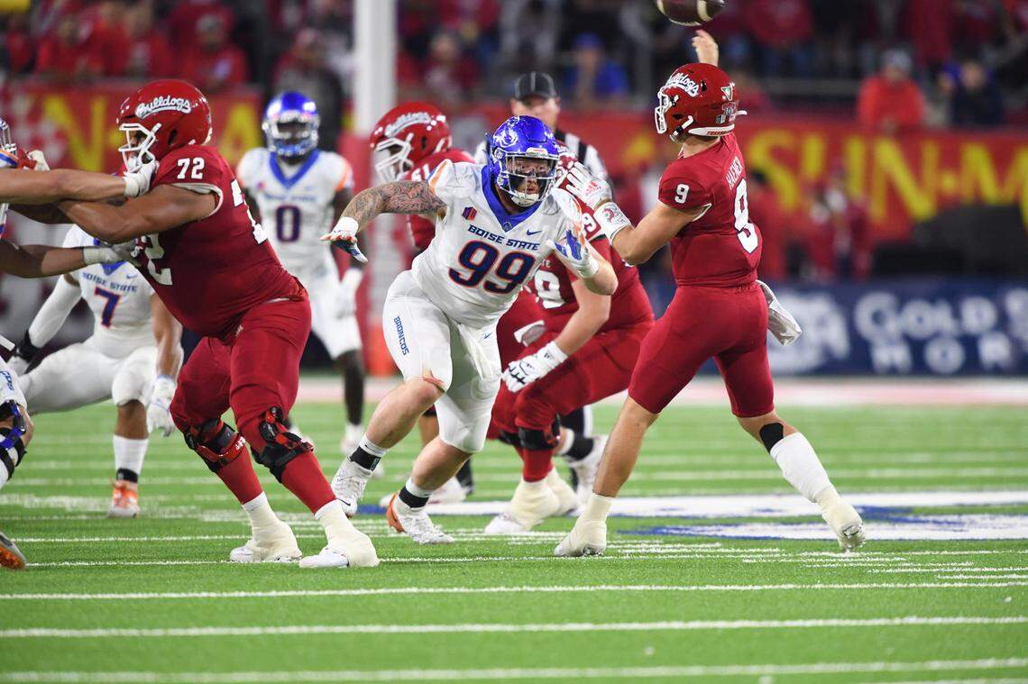 Boise State defensive tackle Scott Matlock puts pressure on Fresno State quarterback Jake Haener. Matlock had a sack to end the first half, which was his seventh of the season.