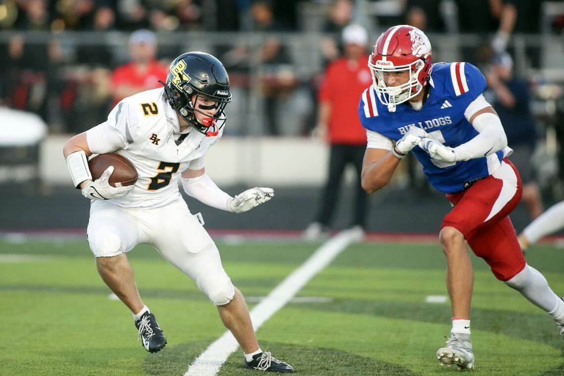Bishop Kelly wide receiver Boston Huskey looks for yards as Nampa defensive back Ryland Rush moves into for a tackle at Nampa, Friday, Sept. 19, 2025.
