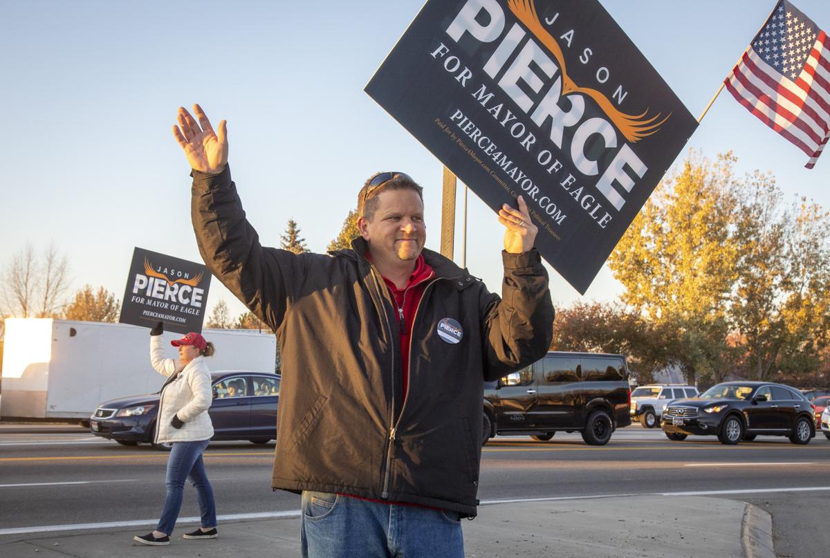 Jason Pierce, along with his wife, Jennifer, and other supporters, waves to early morning commuters at Highway 55 and Eagle Road.