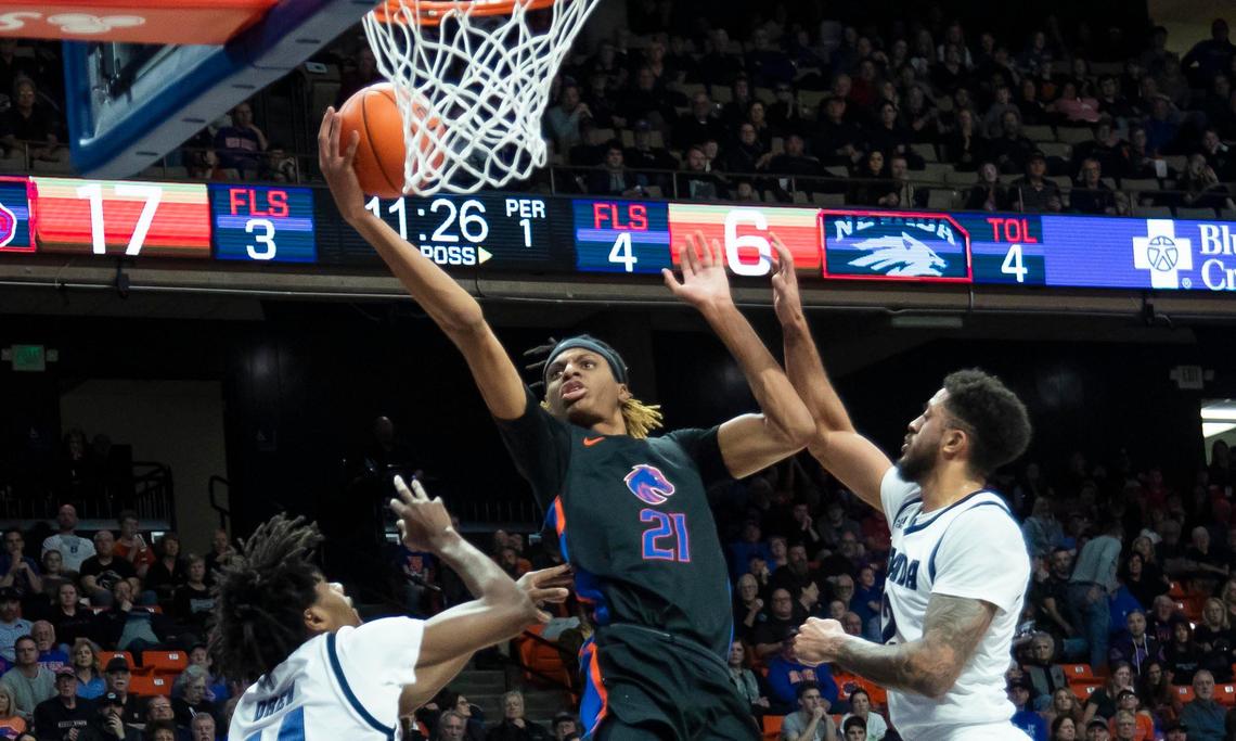 Boise State guard Derrick Alston scores two, plus one, driving through Nevada defenders Jalen Harris and Lindsey Drew in the first half Saturday, Feb. 1, 2020 at ExtraMile Arena in Boise.
