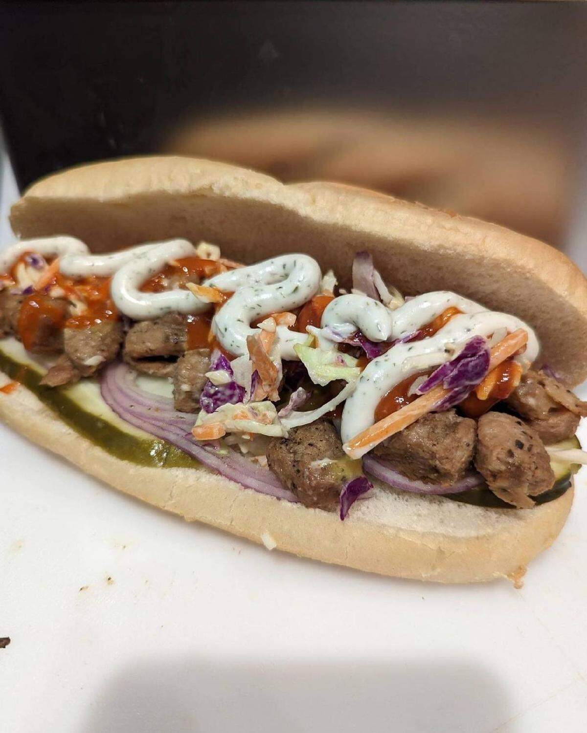 The Buffalo was one of the sandwiches offered at the restaurant. It was made with chopped vegan “chicken,” two pickle slices, sliced red onion, cole slaw, cheddar sauce, buffalo sauce and house ranch.