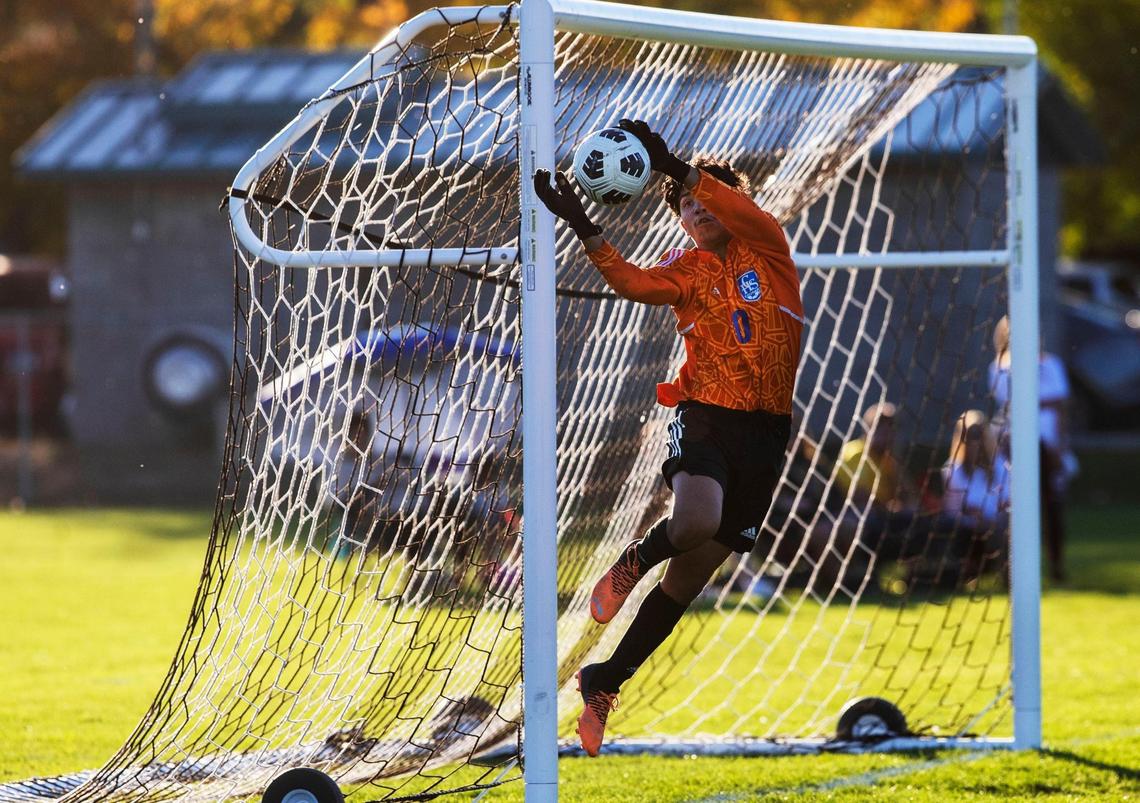 Caldwell goalkeeper Horacio Hernandez leaps and stops a Bishop Kelly shot Thursday in the 4A District Three boys soccer championship at Vallivue High.