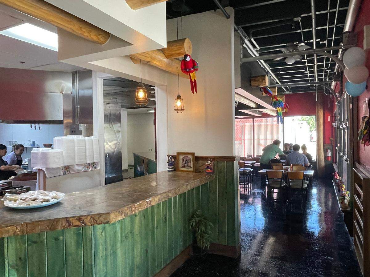 After entering, you are greeted by a view of the open kitchen. Dining areas are on either side.