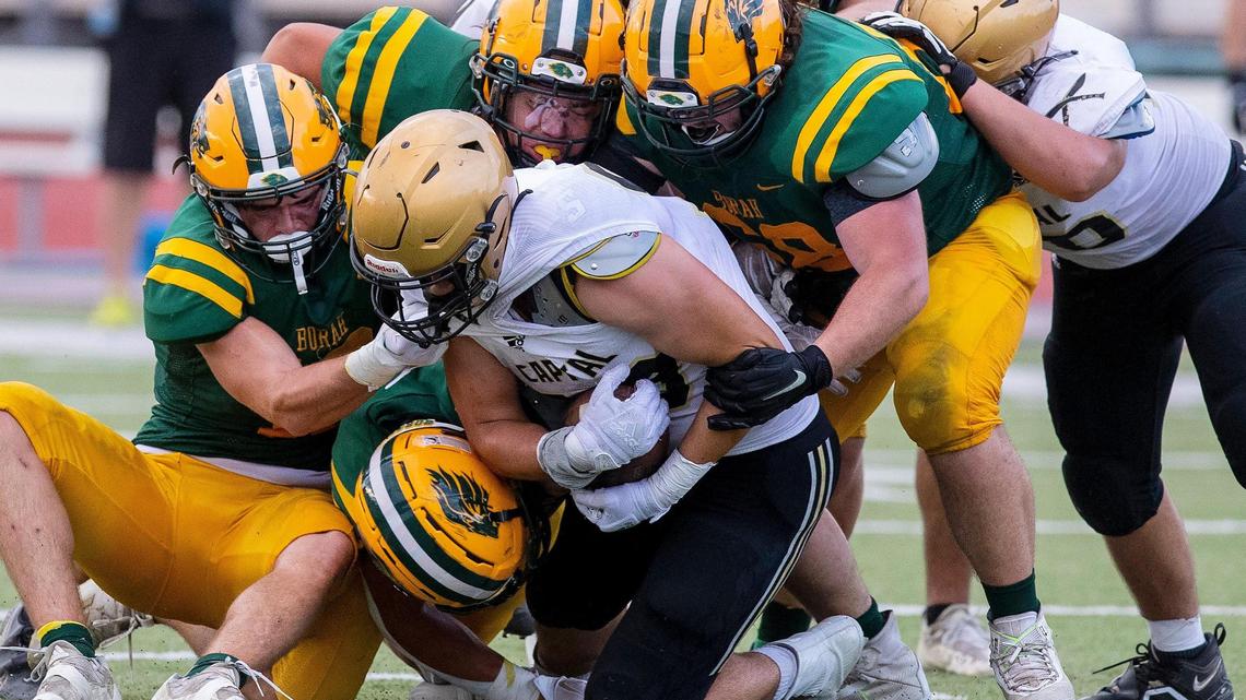 Capital running back Tucker French is brought down by a host of Borah players in the first half of their football game at Dona Larsen Park on Friday.