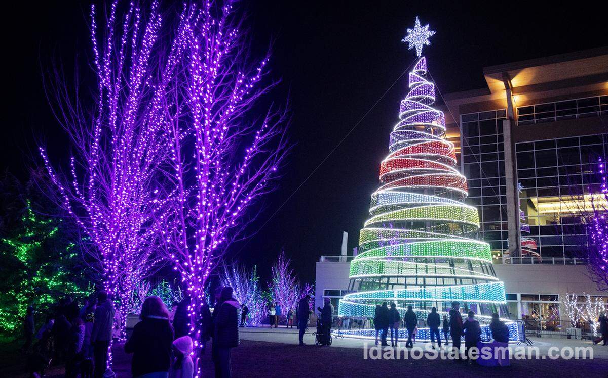 People walk by a 75-foot tall Christmas light tree at Scentsy Commons in Meridian in 2021.