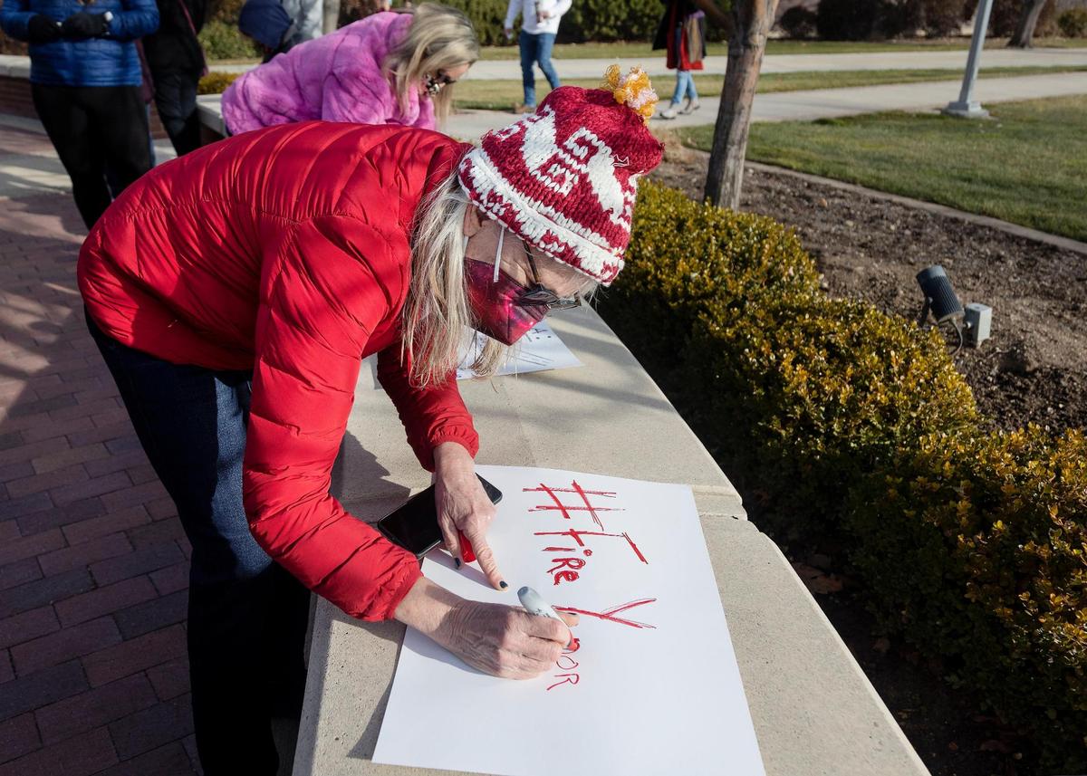 Kristen Cheyney, a Boise State computer science and mathematics alumna, writes a protest sign reading “#FireYenor” in response to comments made by Boise State political science professor Scott Yenor.