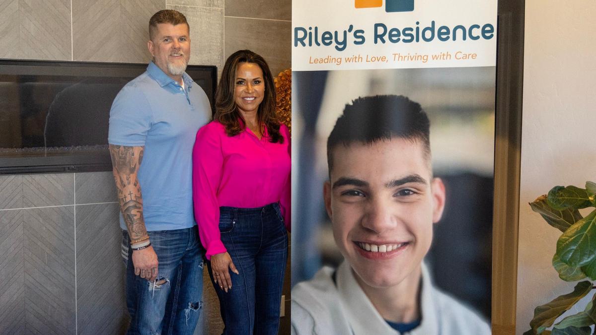 Marty and Michelle Short stand with a poster of Michelle’s son, Riley, the inspiration behind Riley’s Residence.