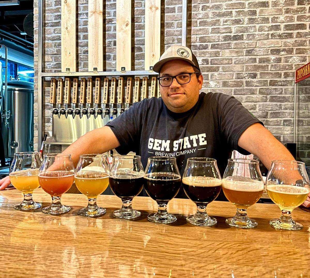 Gem State Brewing co-owner and brewer Chris McGinnis poses in front of launch beers.
