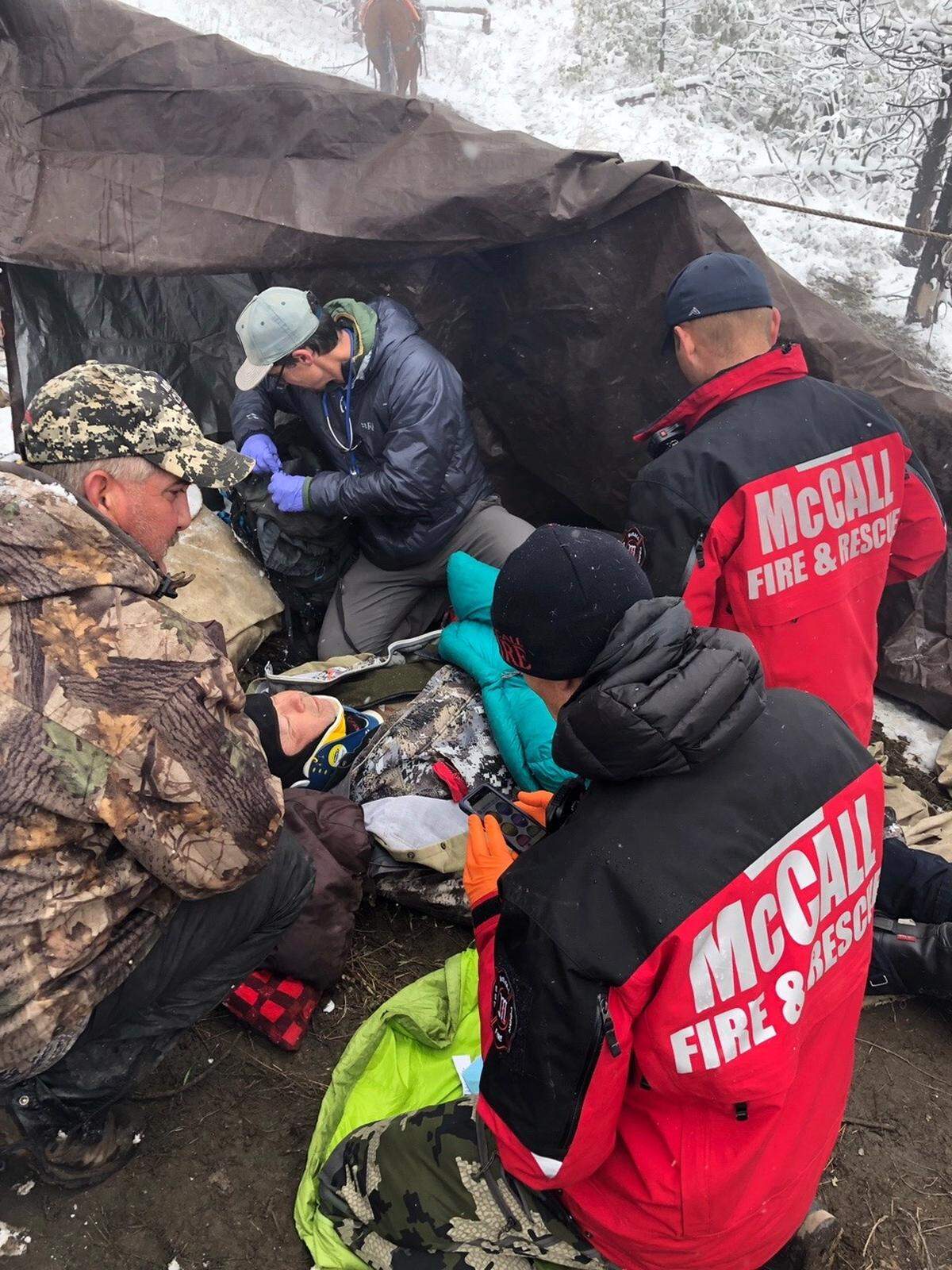 Rescuers prop injured hunter Jeff Harrison upright to be rescued after paramedic Freddie Van Middendorp (right), EMT Tyler Paul (other red jacket) and doctor Danny Griffis (left, black coat) stabilized and packaged him.