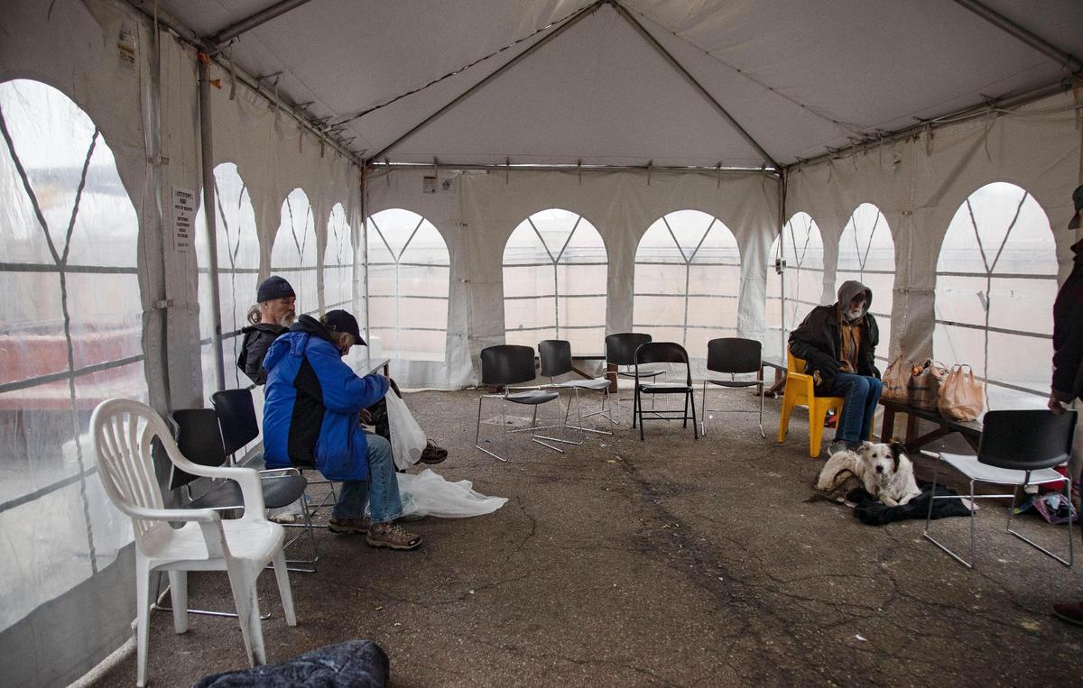 A few guests of Interfaith Sanctuary spend the early afternoon inside a large, heated tent on the Interfaith Sanctuary property on Tuesday, Jan. 18, 2022. Over the weekend the shelter reached its capacity and is now temporarily allowing some unhoused clients to stay overnight in sleeping bags inside the heated tent.
