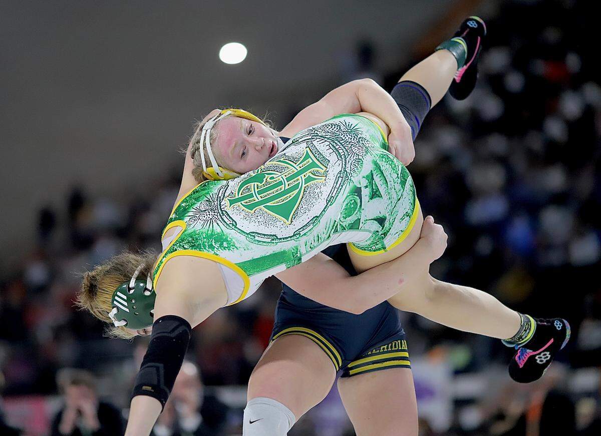 Meridian senior Elise Twait swings to plant Potlatch senior Hayley McNeil on Saturday during their title match at the state championships in Pocatello. Twait won by technical fall, 17–1, to cap an undefeated season with her third straight state title.