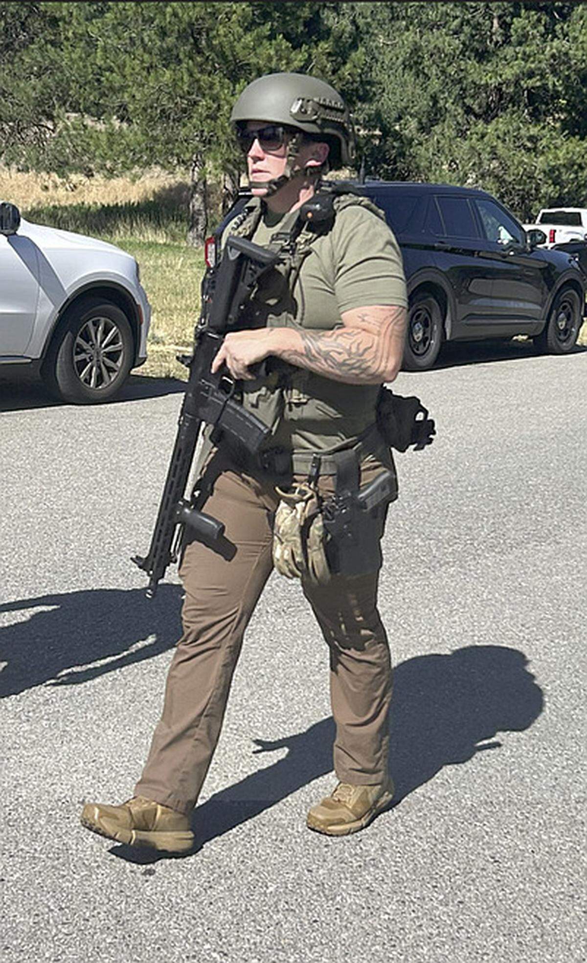 A law enforcement officer at Cherry Hill Park in Coeur d’Alene, near the scene of an ambush attack on firefighters responding to a brush fire Sunday afternoon on Canfield Mountain.