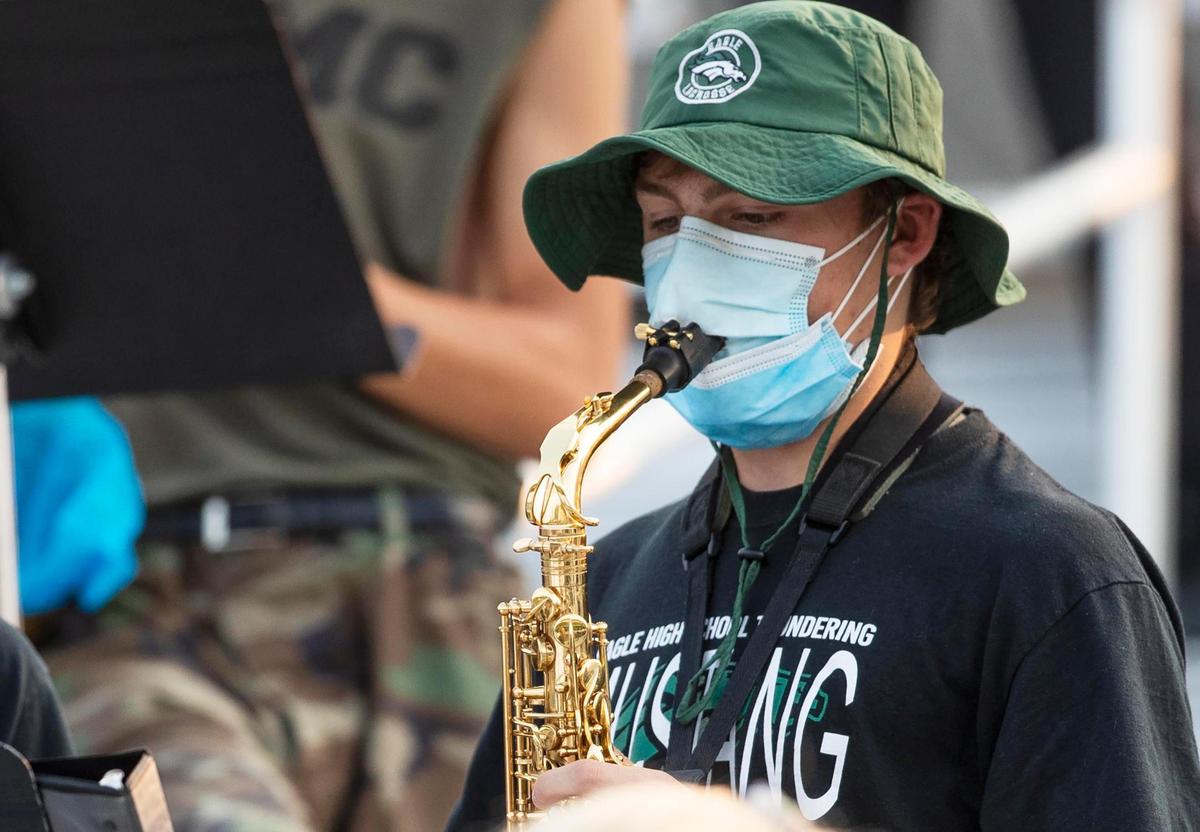 An Eagle High School alto saxophonist takes no chances while playing at the Mountain View football game on Sept. 11 at Thunder Stadium in Eagle.