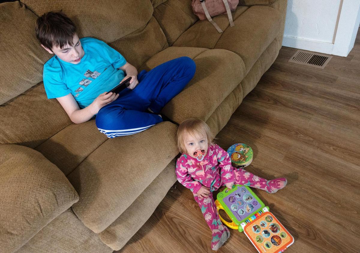 Katie Mengel’s children Kaydyn and Lorelei play in the living room. Mengel is concerned that moving frequently has affected Kaydyn’s education.