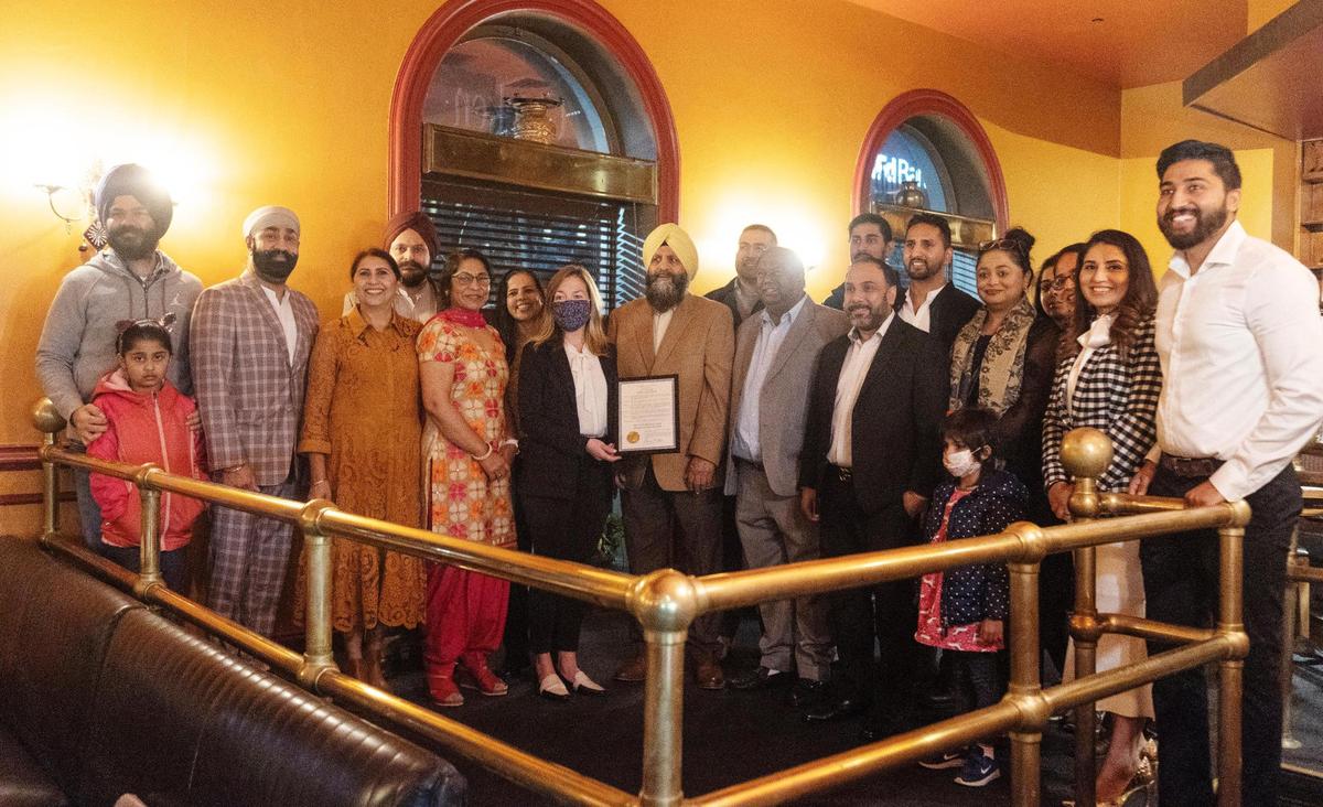 Followers of the Sikh religion in Boise gather around Mayor Lauren McLean for a photograph after she gave a proclamation for Sikh Awareness and Appreciation Month at Bombay Grill.