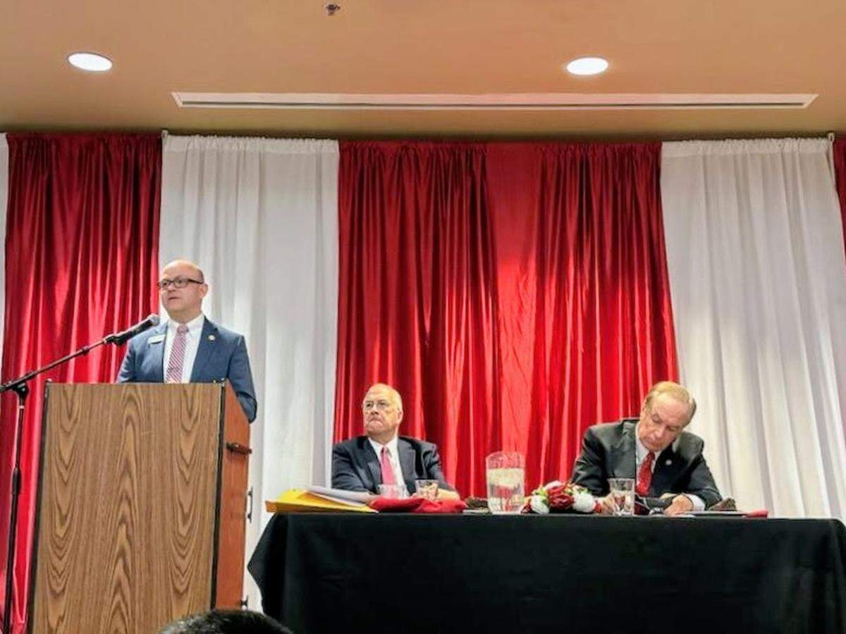 Dirk Kempthorne, right, takes notes while listening to a speech by Idaho Secretary of State Phil McGrane.
