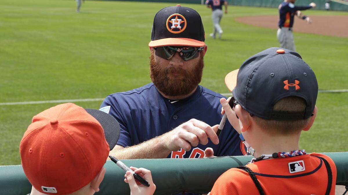 Houston Astros starting pitcher Cy Sneed, center, signs autographs for fans before a spring baseball exhibition game against the Atlanta Braves, Monday, March 4, 2019, in Kissimmee, Fla. (AP Photo/John Raoux)