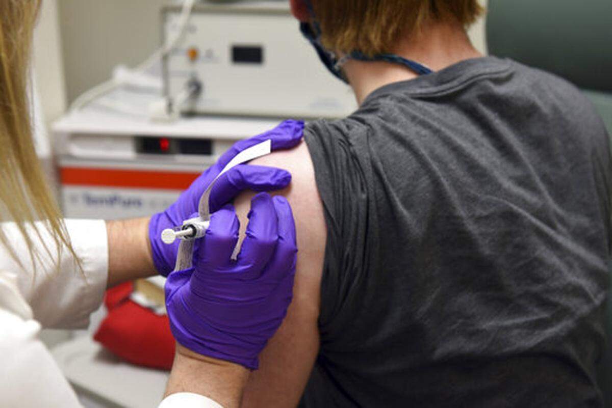 In this May 4, 2020, photo distributed by the University of Maryland School of Medicine in Baltimore, a patient enrolled in clinical trials of a Pfizer COVID-19 vaccine receives an injection.