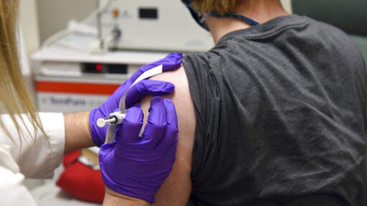In this May 4, 2020, photo distributed by the University of Maryland School of Medicine in Baltimore, a patient enrolled in clinical trials of a Pfizer COVID-19 vaccine receives an injection.