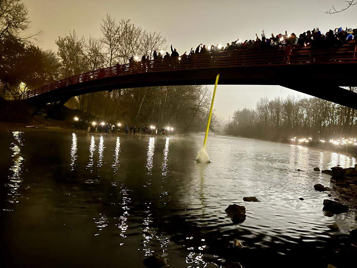 Boise State fans throw an upright into the Boise River off the Bob Gibb Friendship Bridge after the Broncos beat UNLV 21-7 in the Mountain West Championship game.