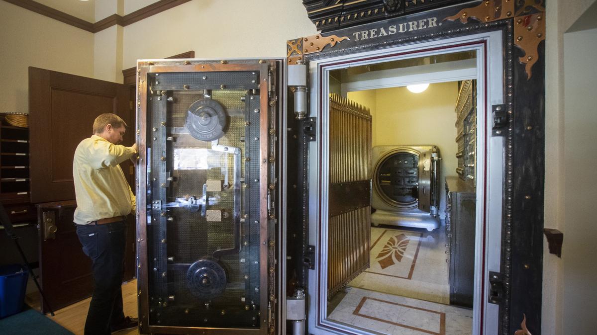 The state Capitol was built around the treasurer’s vault in 1905, and it’s still used by state Treasurer Julie Ellsworth. Lincoln Smyser, communications director and analyst, hefts open the massive safe door.