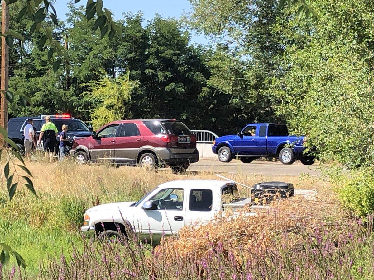 Police investigate a crash involving a bicycle and two vehicles on Eagle Road at Beacon Light Road Friday. The white pickup ended up in a ditch below Eagle Road; the red car had front-end damage.