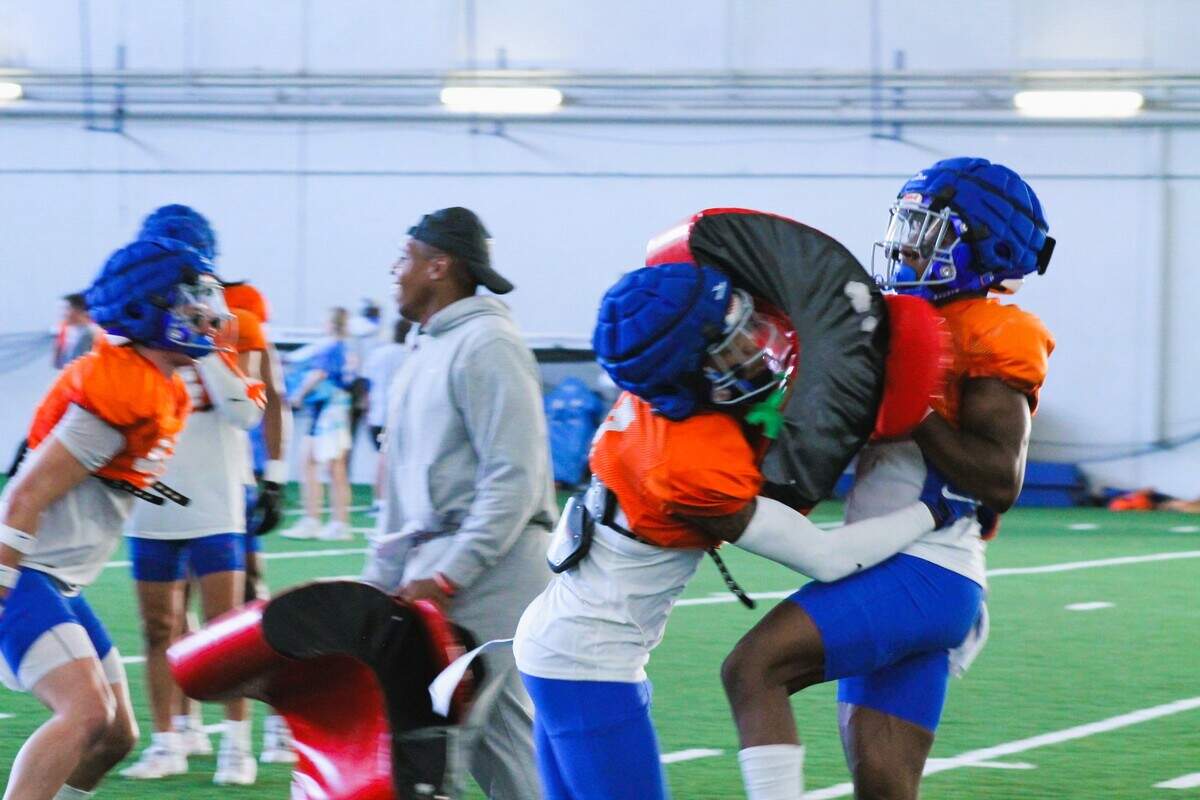 Boise State cornerback A’Marion McCoy hits a tackling pad held by fellow cornerback Jeremiah Earby during fall practice. McCoy and Earby grew up together and were teammates at Menlo-Atherton High School in California.