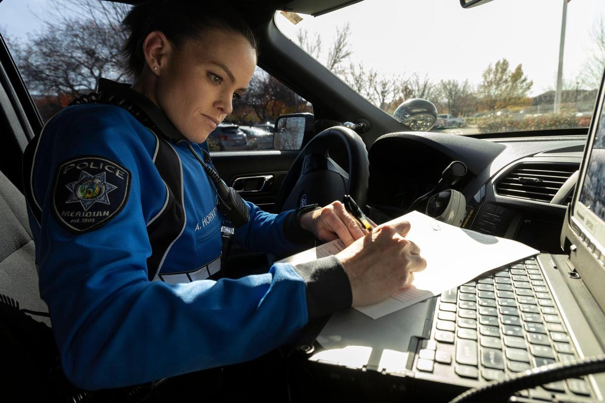 A Meridian police officer completes paperwork after handling a mental health-related emergency.