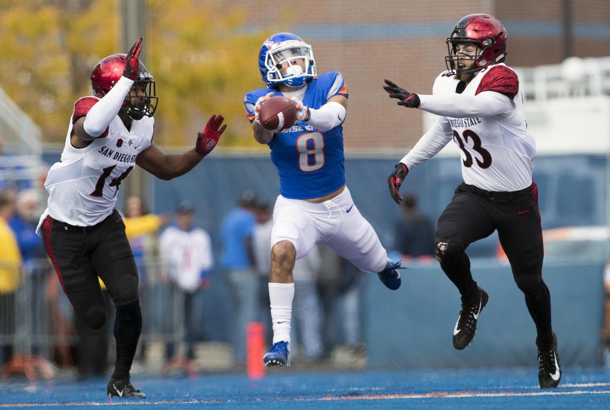Boise State wide receiver Sean Modster (8) has a long pass slip through his fingers in the first quarter as San Diego State defenders Tariq Thompson (14) and Parker Baldwin (33) keep in step Saturday, Oct. 6, 2018 at Albertsons Stadium in Boise.