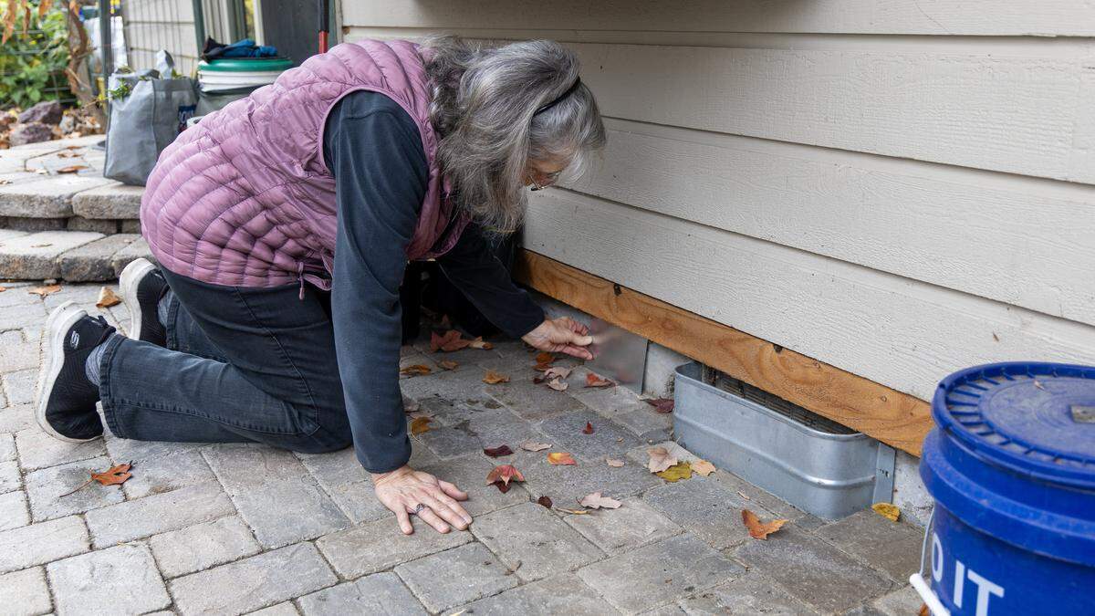 Jane Rohling points out a metal sheet she uses to cover an unused duct to keep out rodents at her Eagle home.