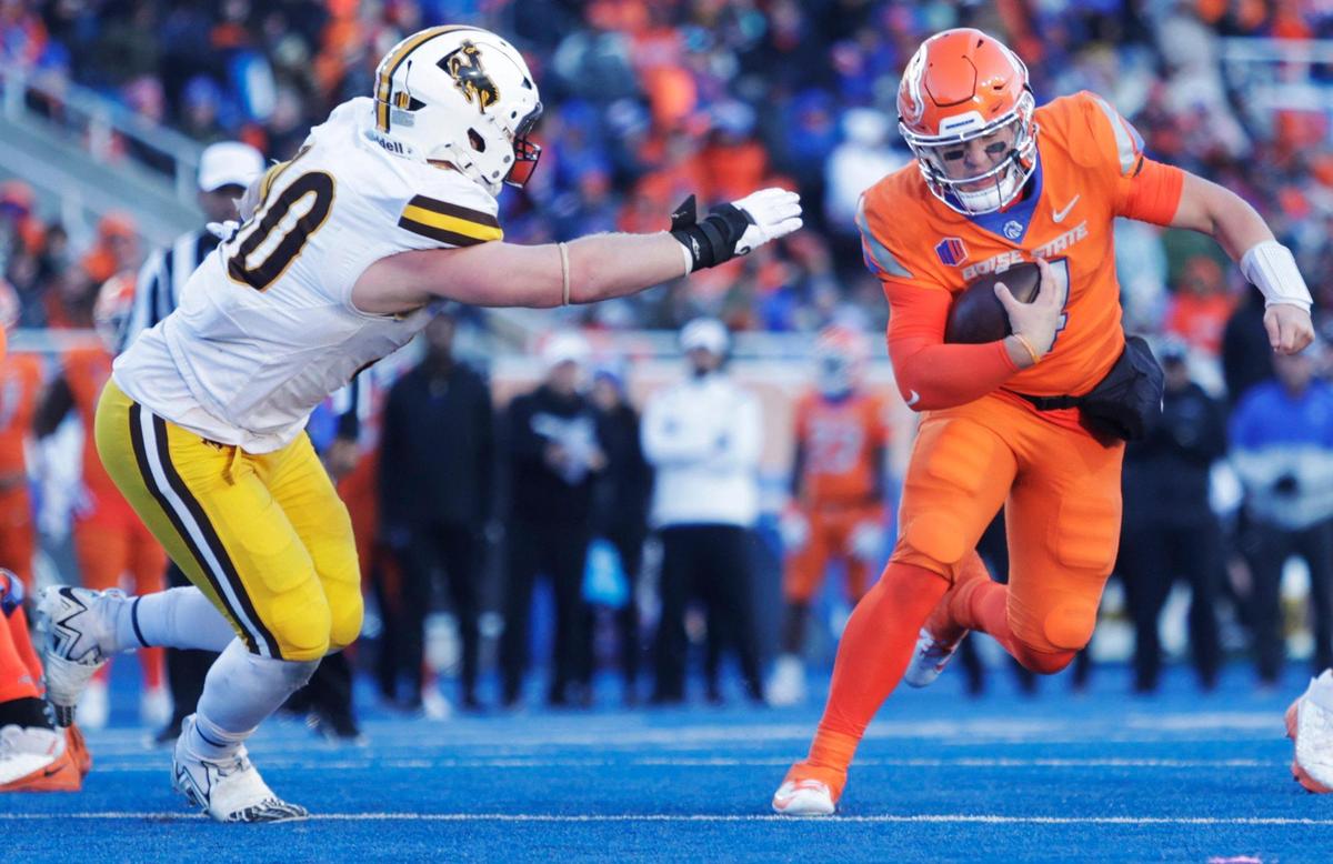 Boise State quarterback Maddux Madsen eludes a tackle by Wyoming nose tackle Gavin Meyer on Saturday at Albertsons Stadium. Boise State defeated Wyoming 32-7.