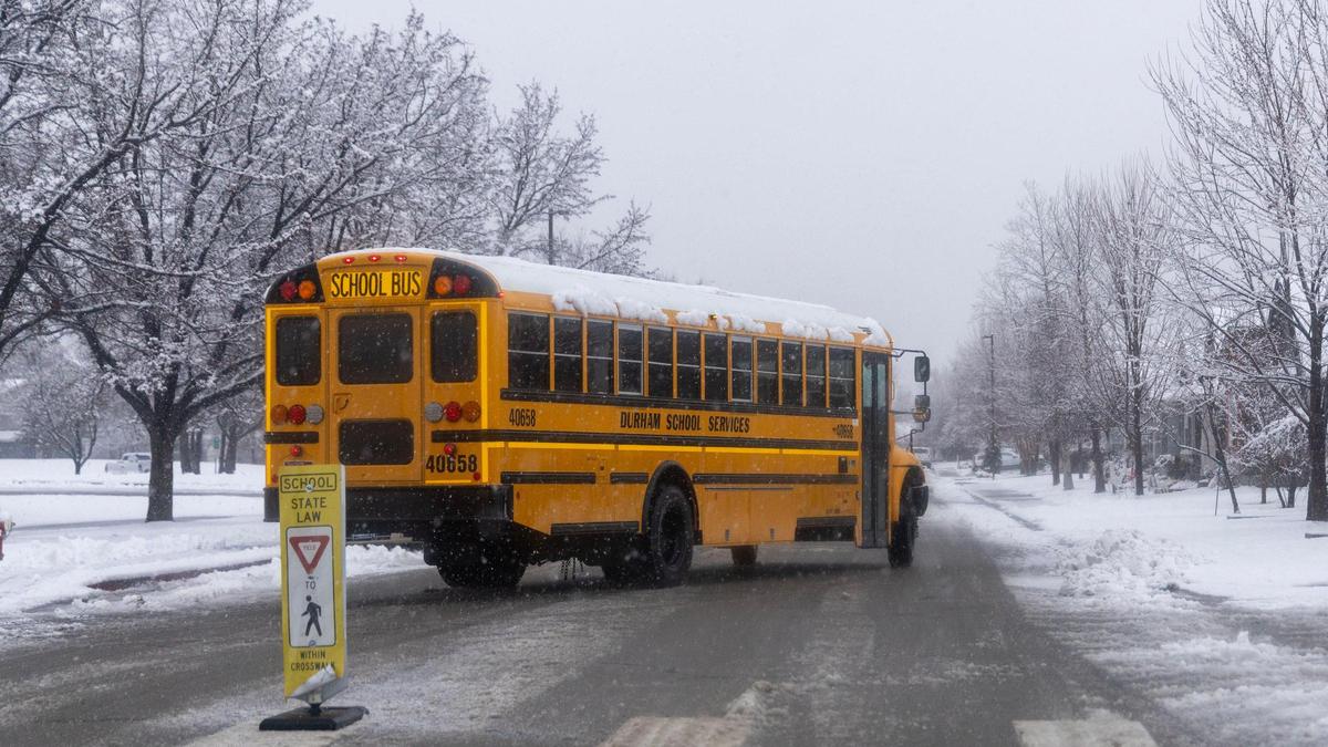 A schoolboy exits a Boise school, navigating slushy roads after a storm dropped inches of snow on the roads.