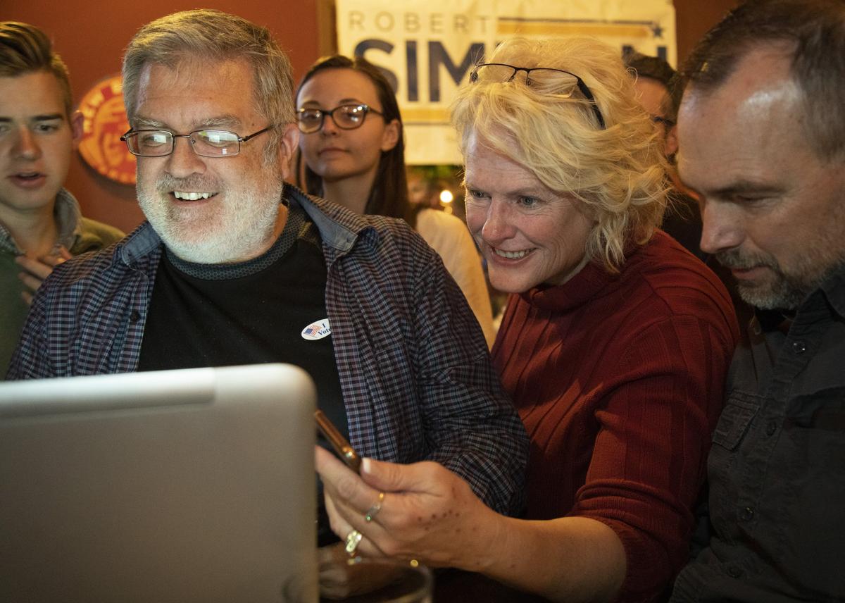 Meridian Mayor Tammy de Weerd, center, and Robert Simison’s campaign manager Eric Cawley, left, watch election returns.