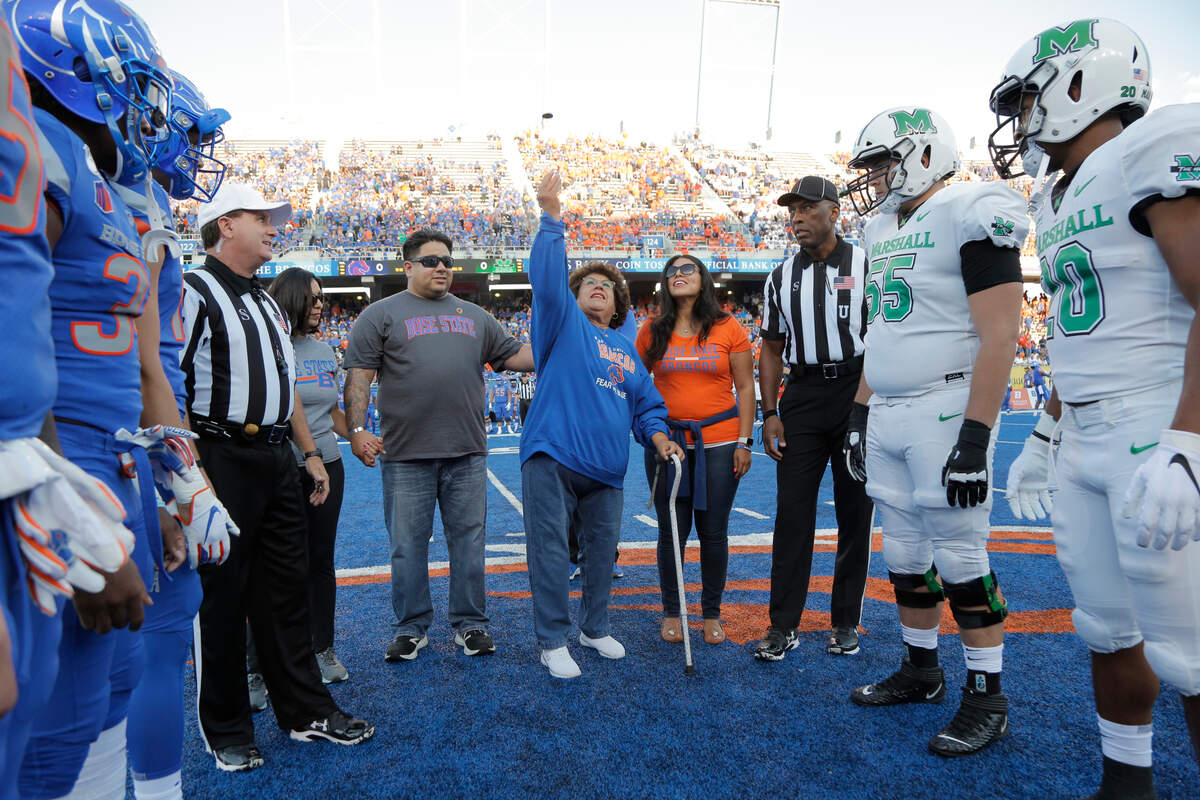 Carolyn Gusman flips the coin before the 2019 Boise State-Marshall game at Albertsons Stadium. Her son, Paul Reyna, died during his freshman fall camp with the Broncos in 1999.