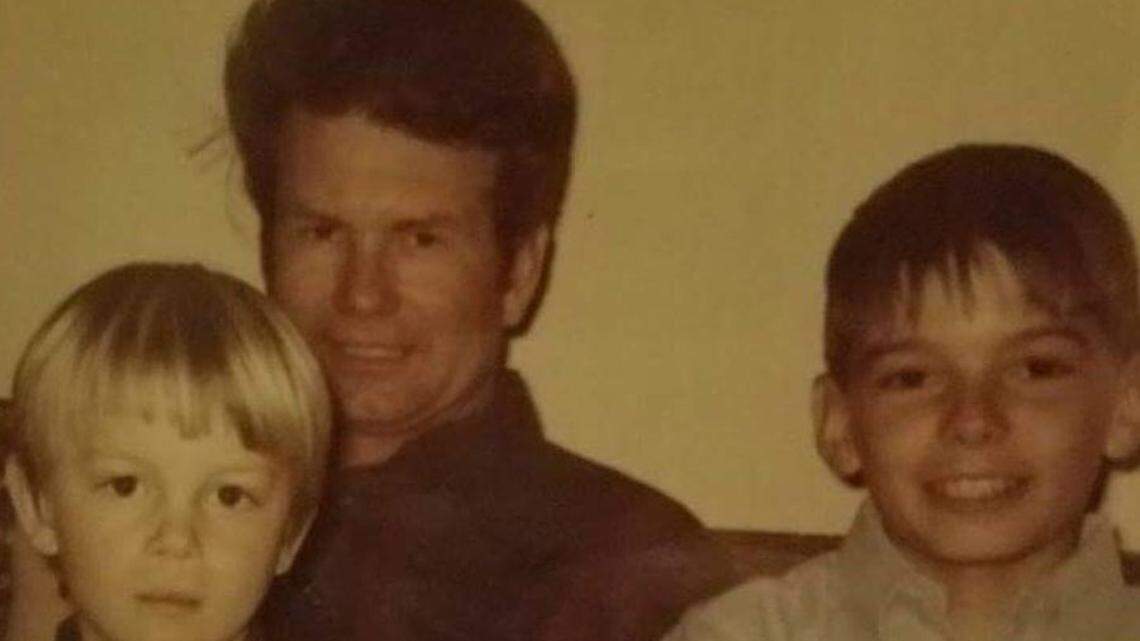 Kirk Guidinger sits on his stepfather’s lap next to his stepbrother, David Jensen, when they were children.