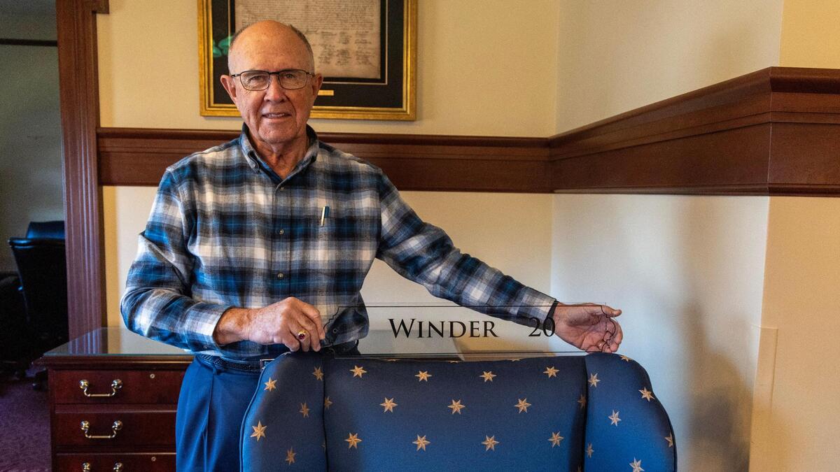 Sen. Chuck Winder holds his name plate from the floor of the Idaho Senate.