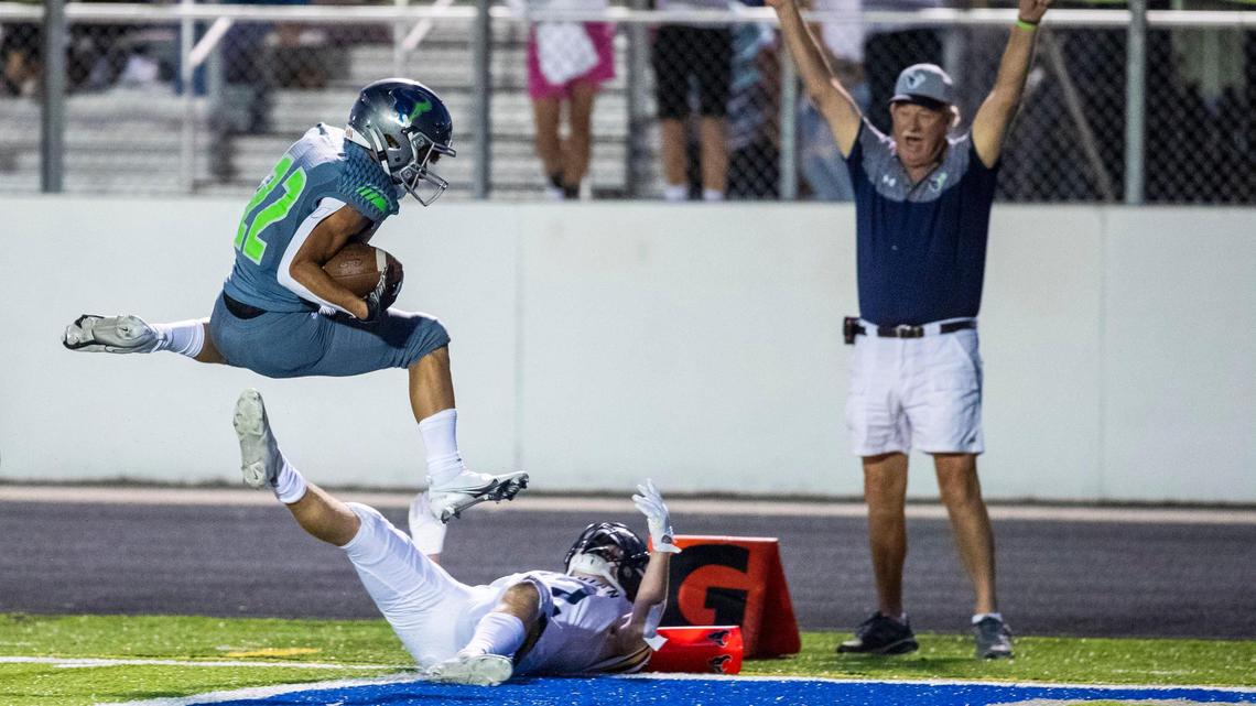 Mountain View running back Dallas Slocum leaps into the end zone for the game-winning touchdown over Meridian’s Bryce Norwood on Friday at Mountain View High School. The Mavericks rallied in the second half to win the season opener 14-13.