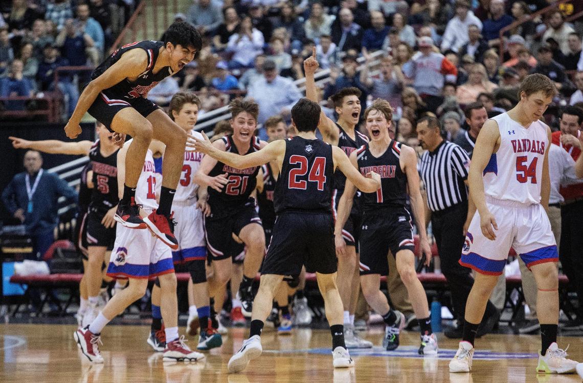 Kimberly’s Alejandro Paz, left, jumps in the air to celebrate their 40-22 win over McCall-Donnelly for the 3A boys basketball state championship title on Saturday.