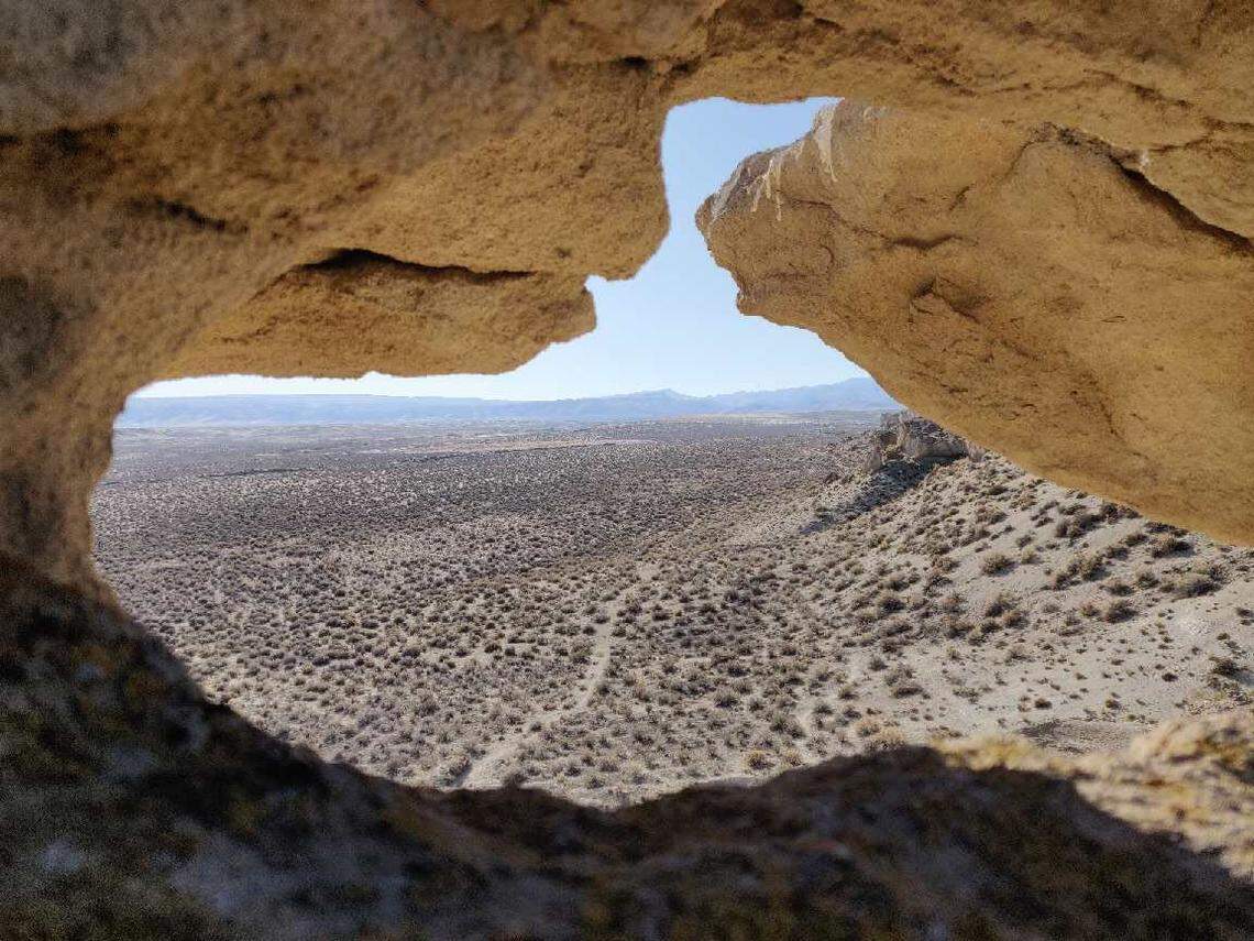 Unusual rock formations at the Shoofly Oolite Interpretive Trail near Grand View form arches that frame the Owyhee Mountains to the west.