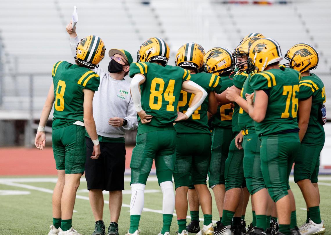 Borah assistant coach Hunter Kenyon holds up a play for the Lions during pregame warmups Thursday at Dona Larsen Park. Hunter is one of two sons of Quane Kenyon, a longtime Borah assistant coach who returned to the sidelines this season to work with his sons.