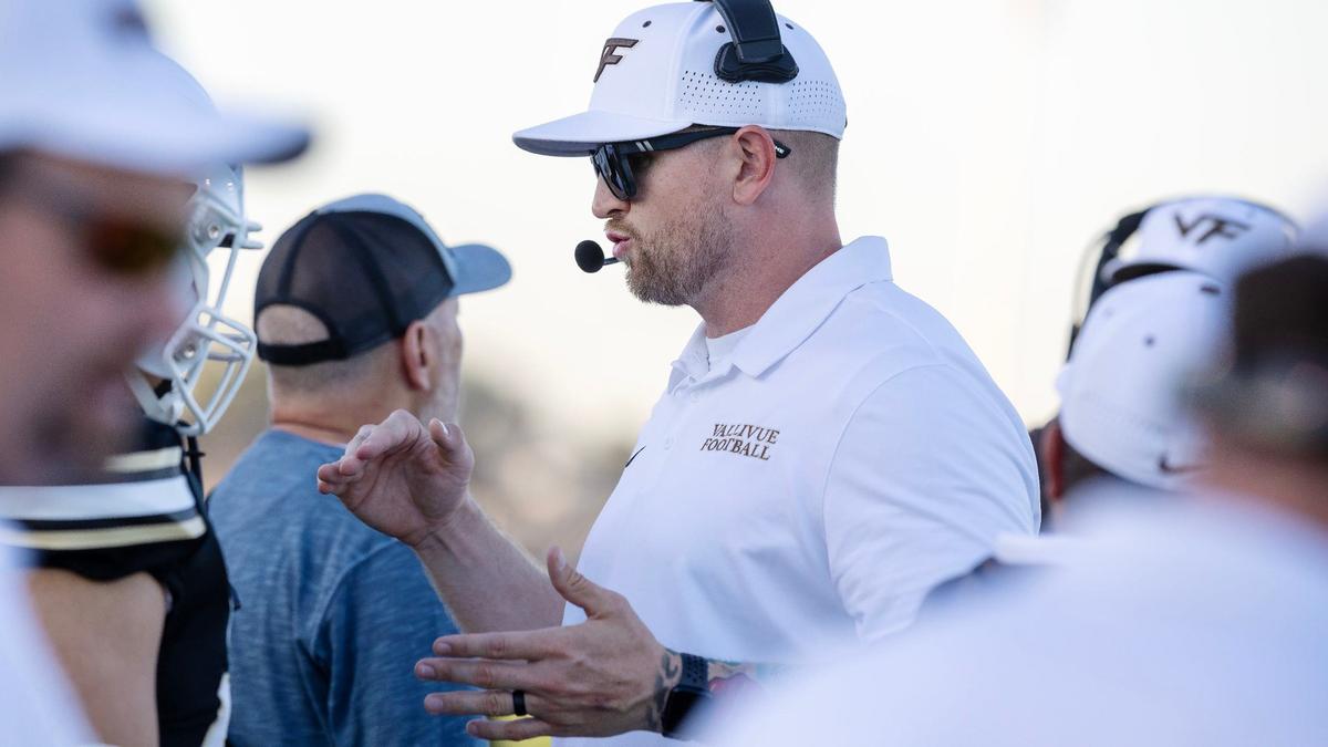 Vallivue coach Shea McClellin talks with his players before the start of their game Friday against Emmett.