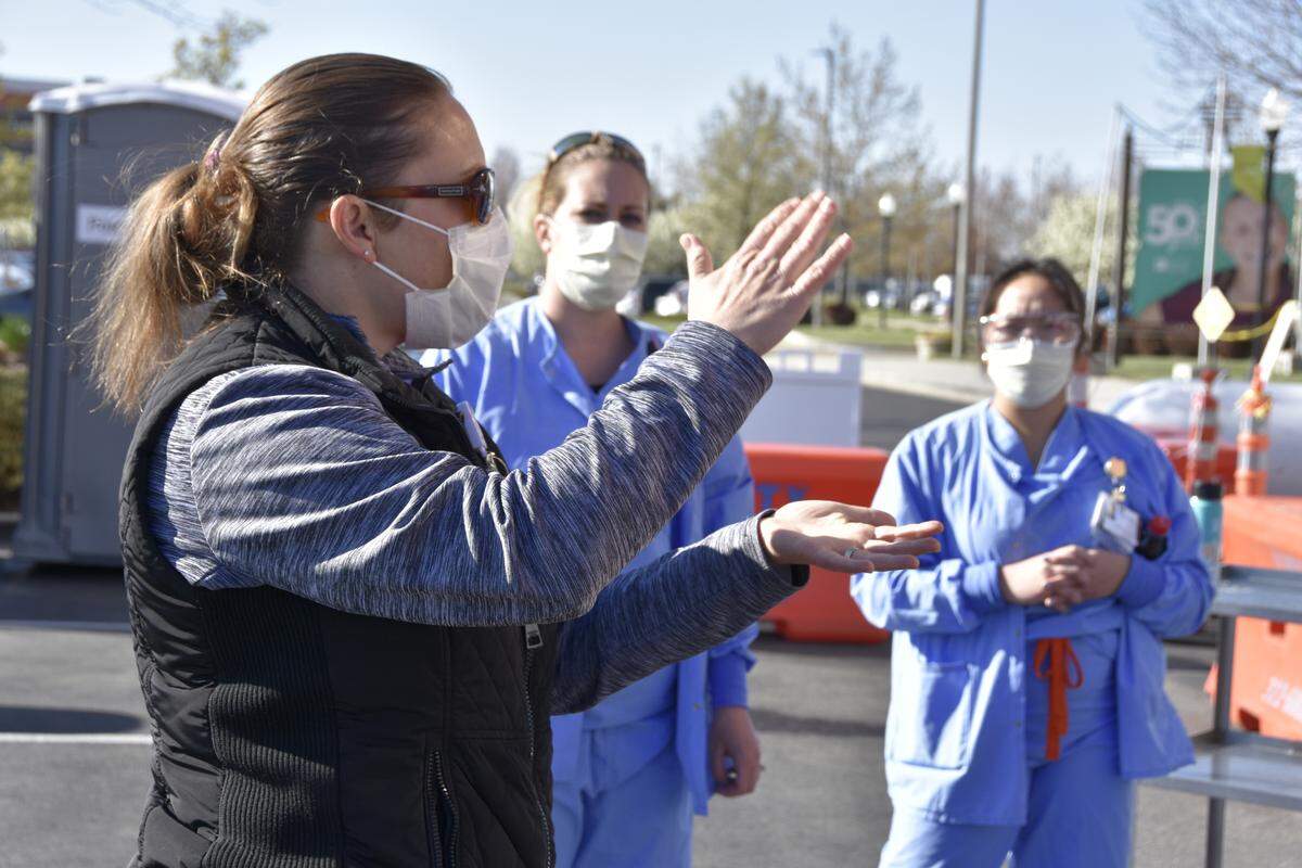 Heather Knapp, who usually works as a pediatric trauma educator, gathers nurses for a “safety huddle” before they start their shift at the drive-thru coronavirus testing site Friday morning at St. Luke’s Meridian Medical Center.