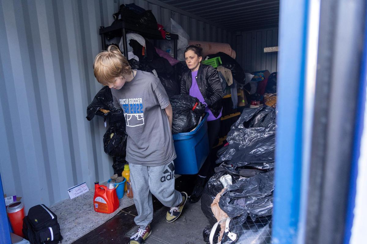 Rachel Church and her son Elliot, 12, move personal items out of a storage unit into a vehicle as they prepare to leave the Airport Inn hotel where they live and Rachel works as a manager. Residents at the Airport Inn are being evicted.