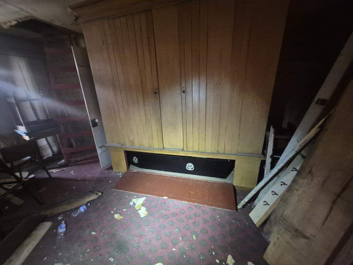 A photo shows the black coffin in a panel below a large cabinet.